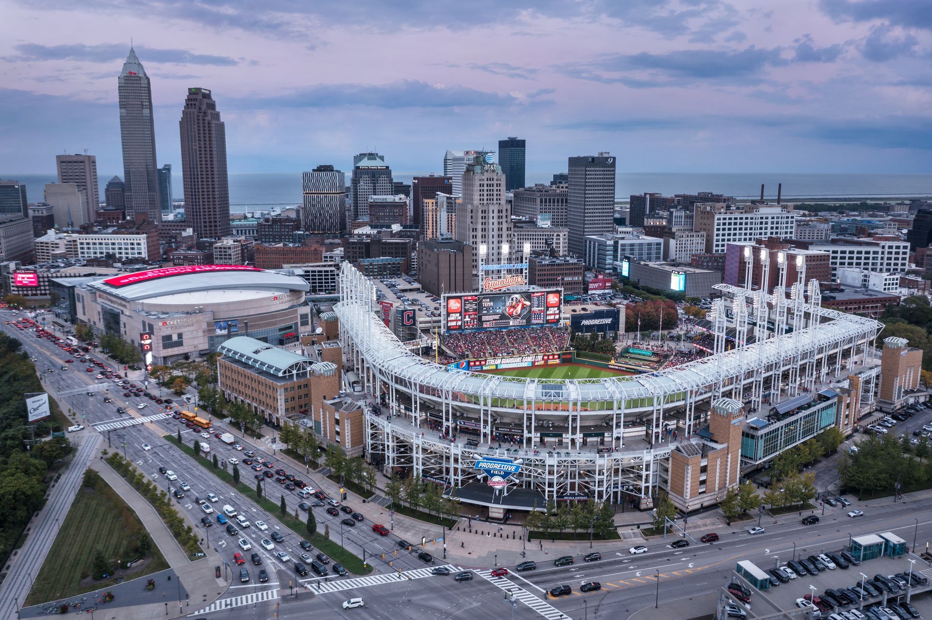 An aerial view of a baseball stadium in a city with a city skyline in the background.