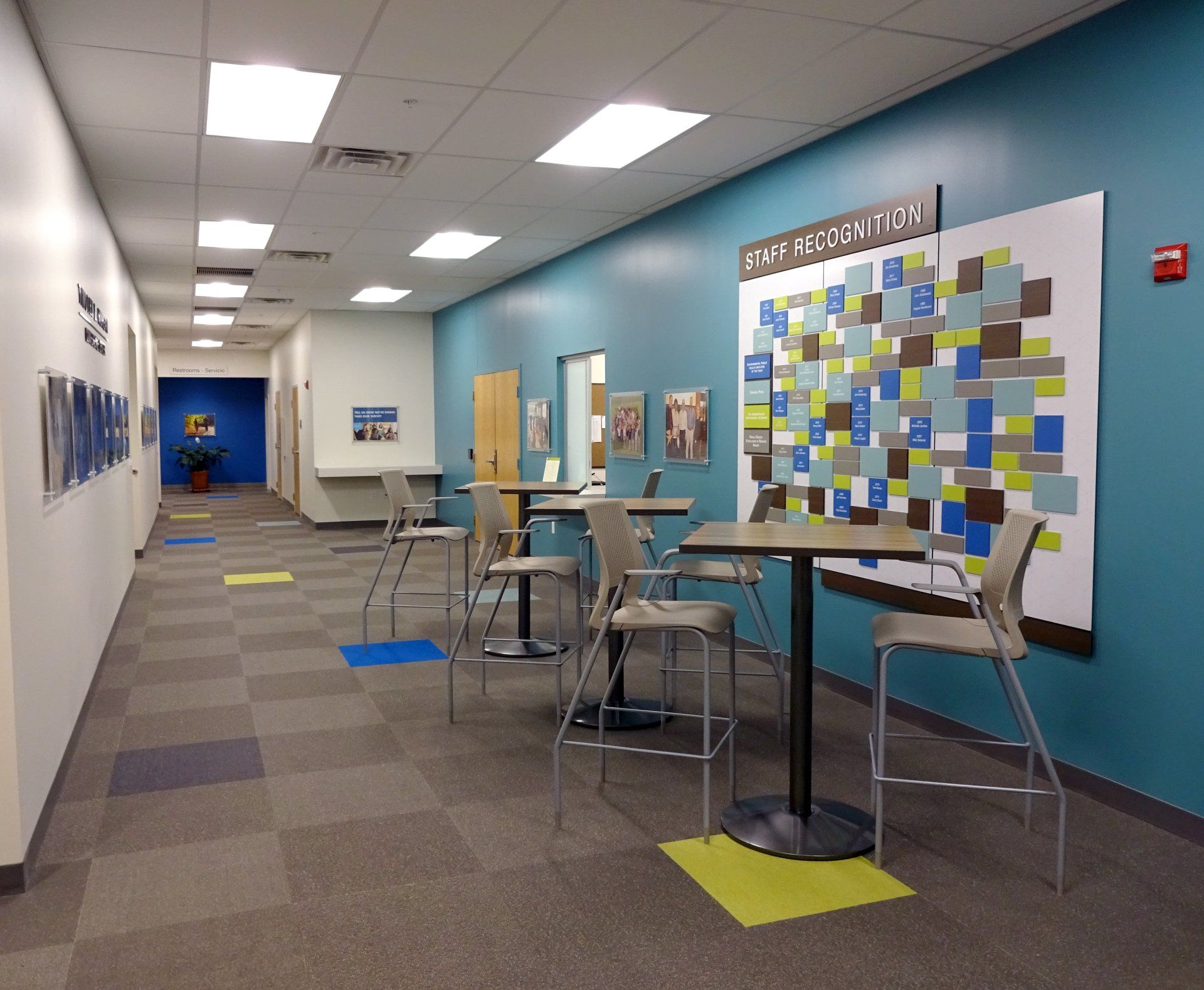 A hallway with tables and chairs and a sign on the wall that says information