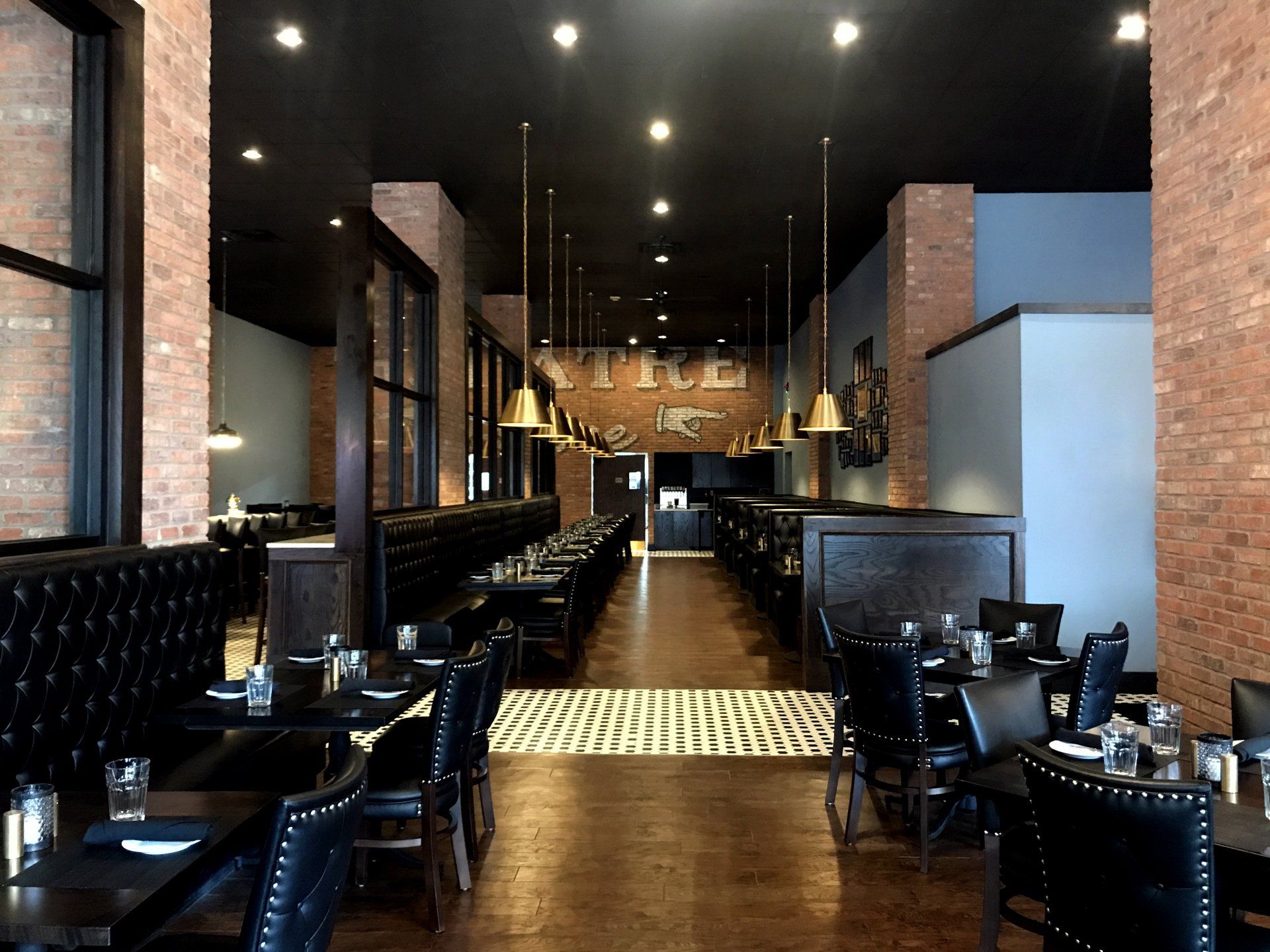 A restaurant with tables and chairs and a brick wall