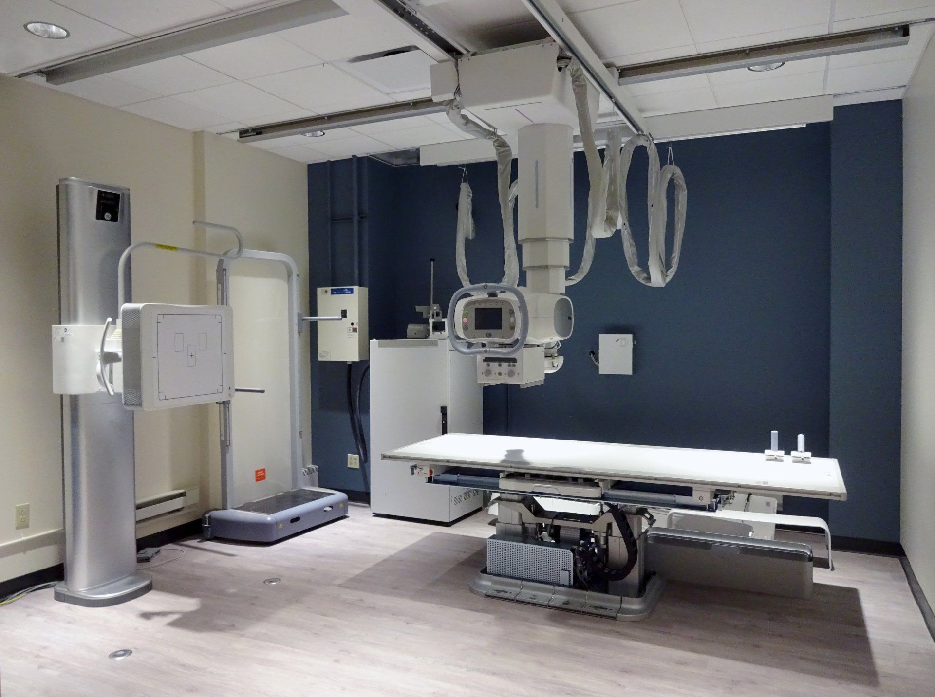 An x-ray machine is hanging from the ceiling of a room