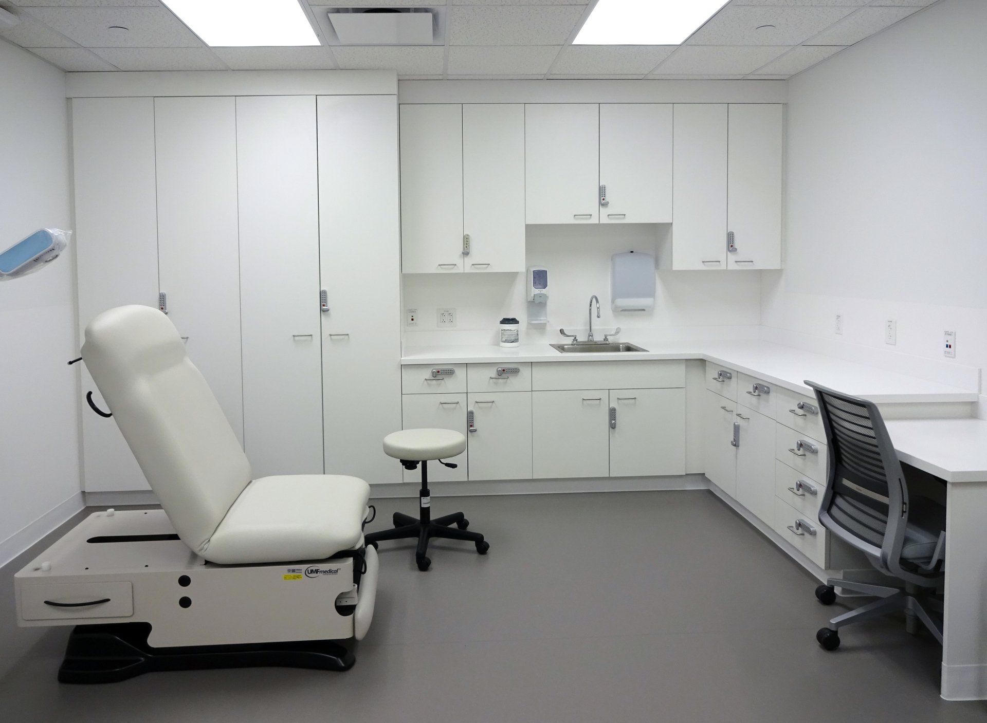 A doctor 's office with a chair and a desk