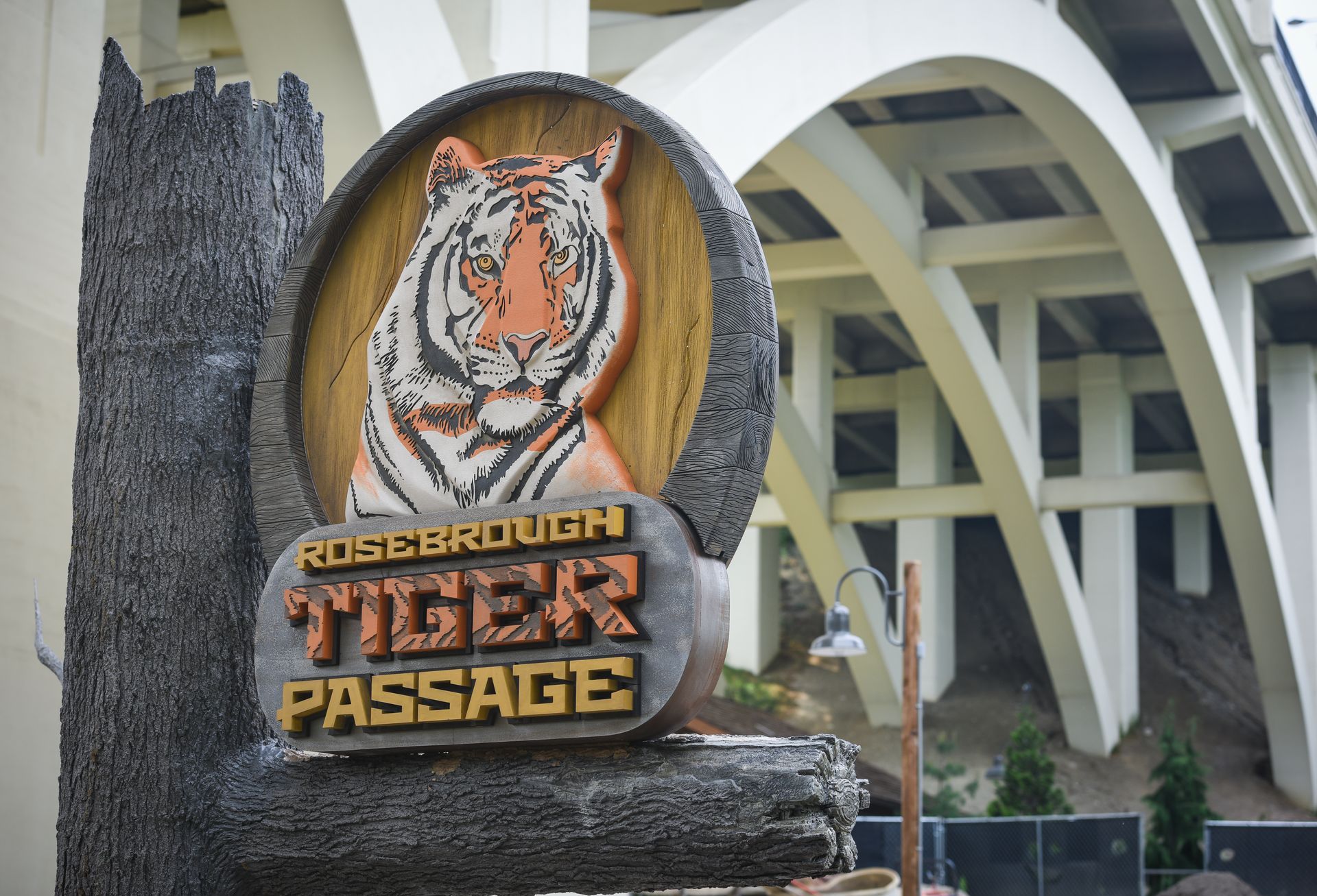 A sign that says tiger passage in front of a bridge