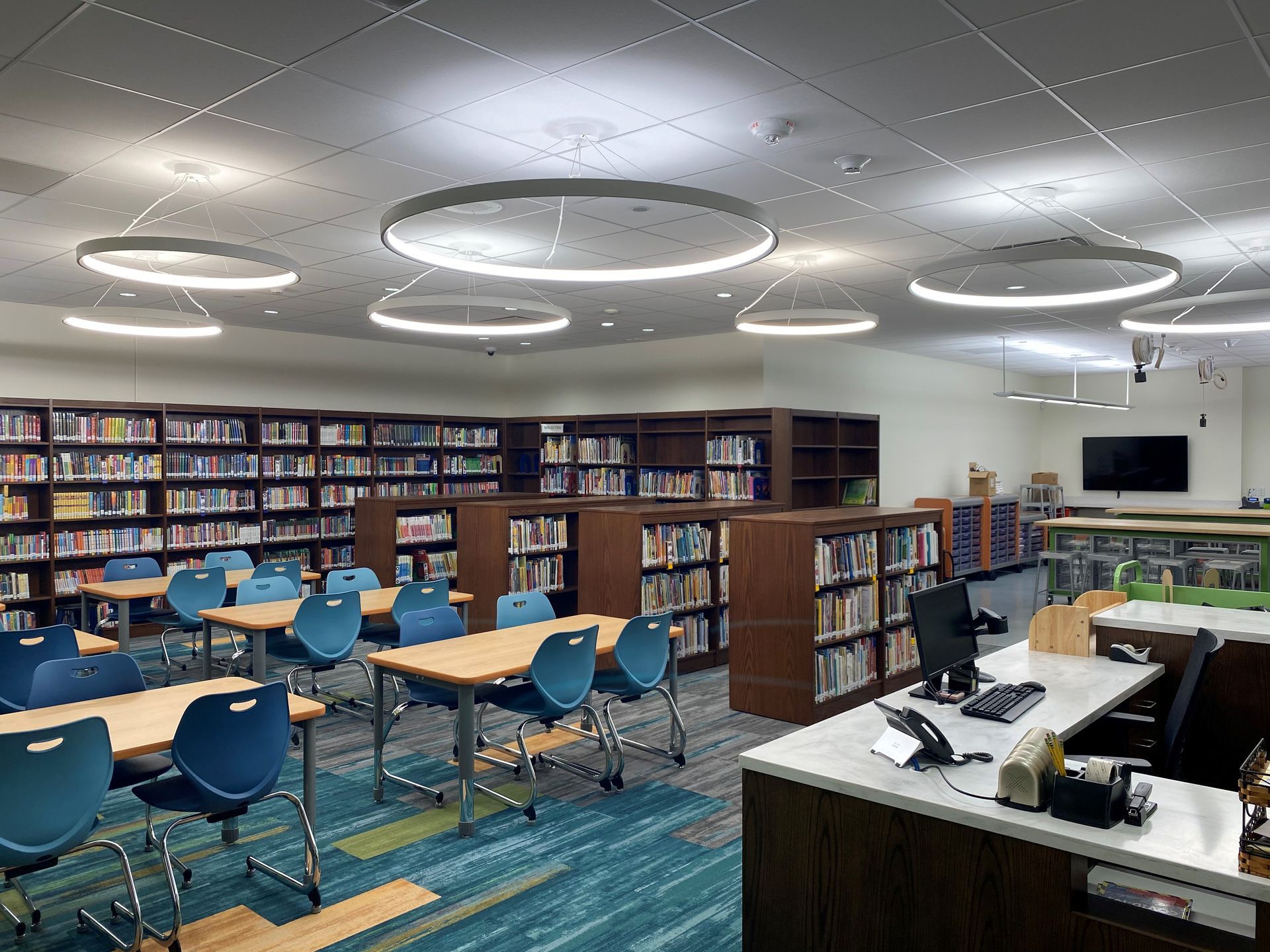 There are many tables and chairs in the library.