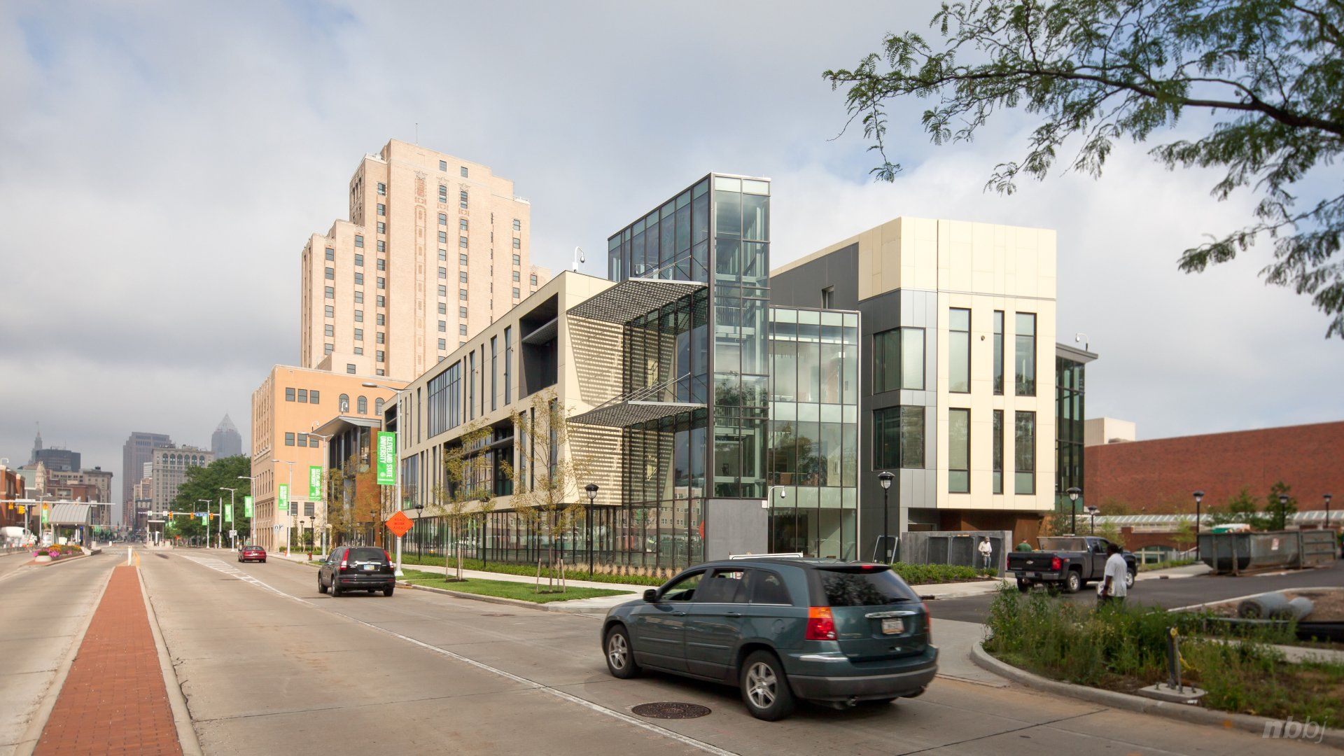 A car is driving down a street in front of a building