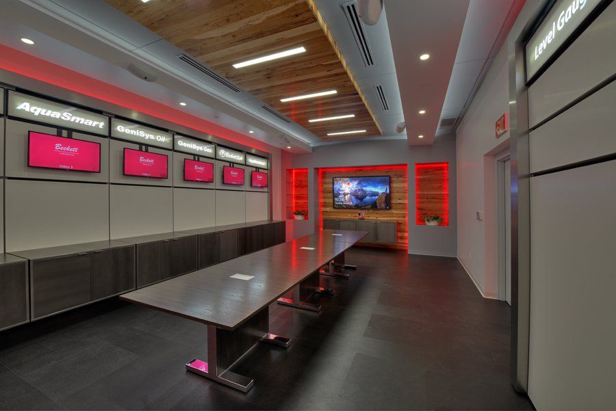 A conference room with a long table and a television on the wall.
