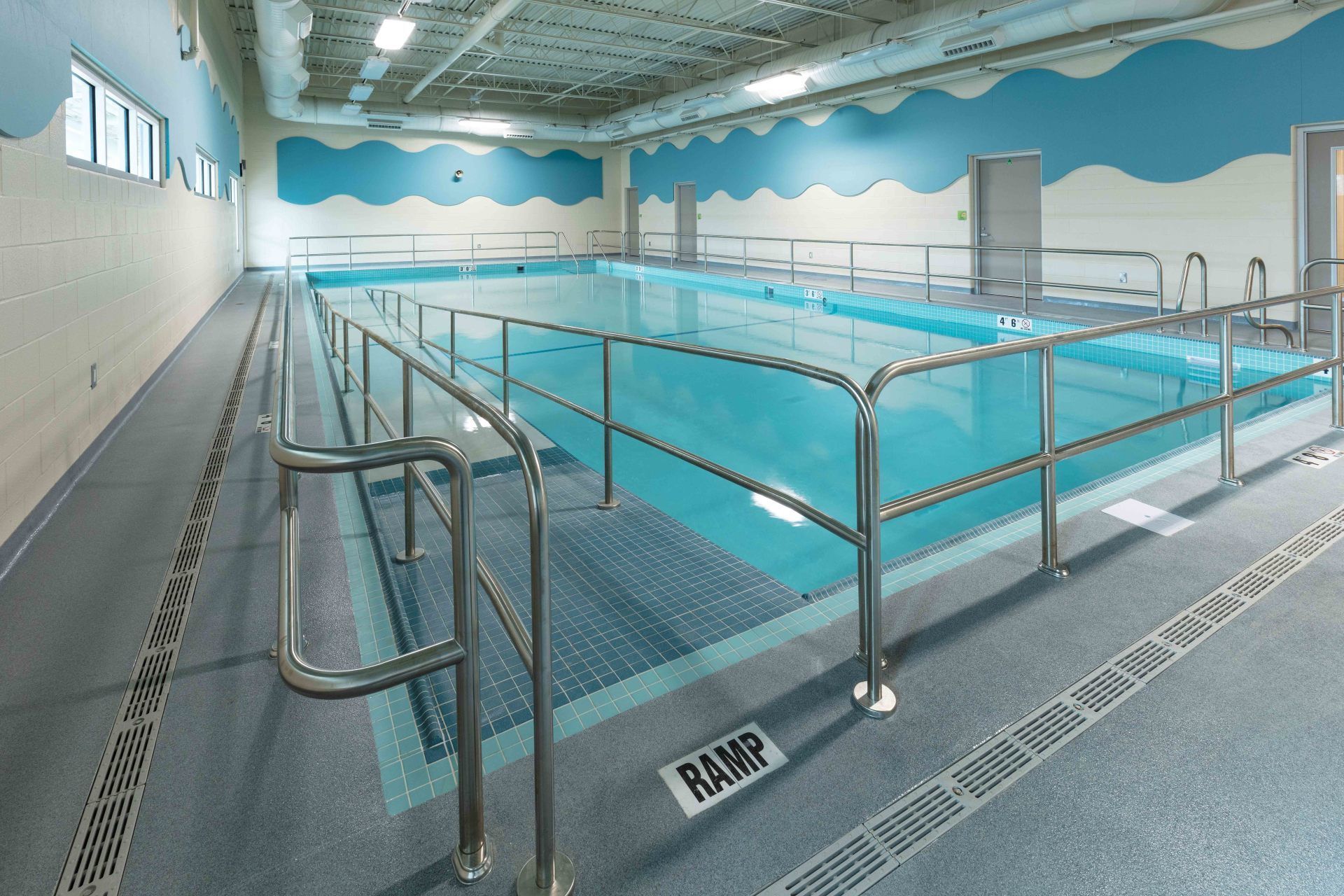 A large indoor swimming pool with a ramp leading to it