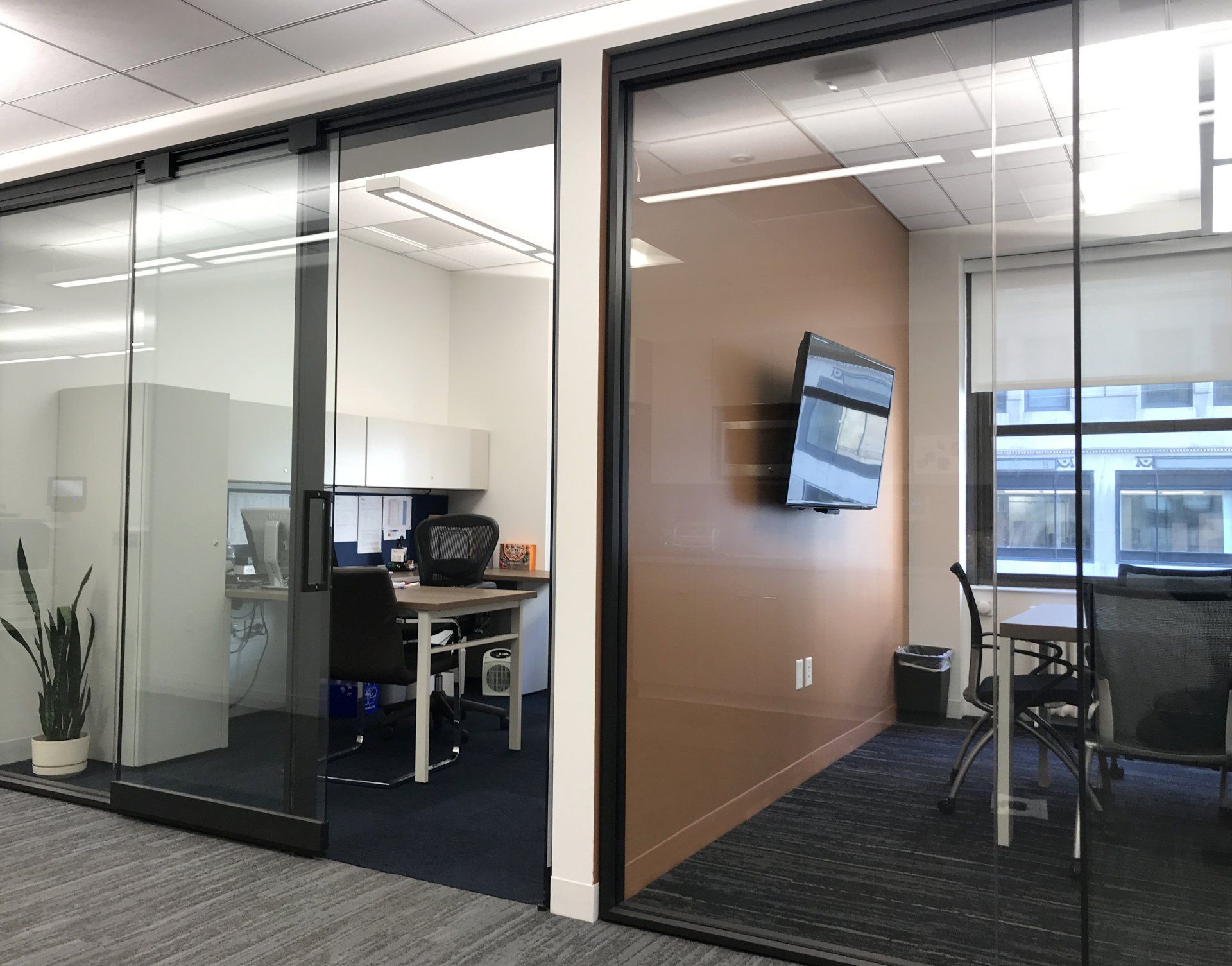 A conference room with sliding glass doors and a desk.