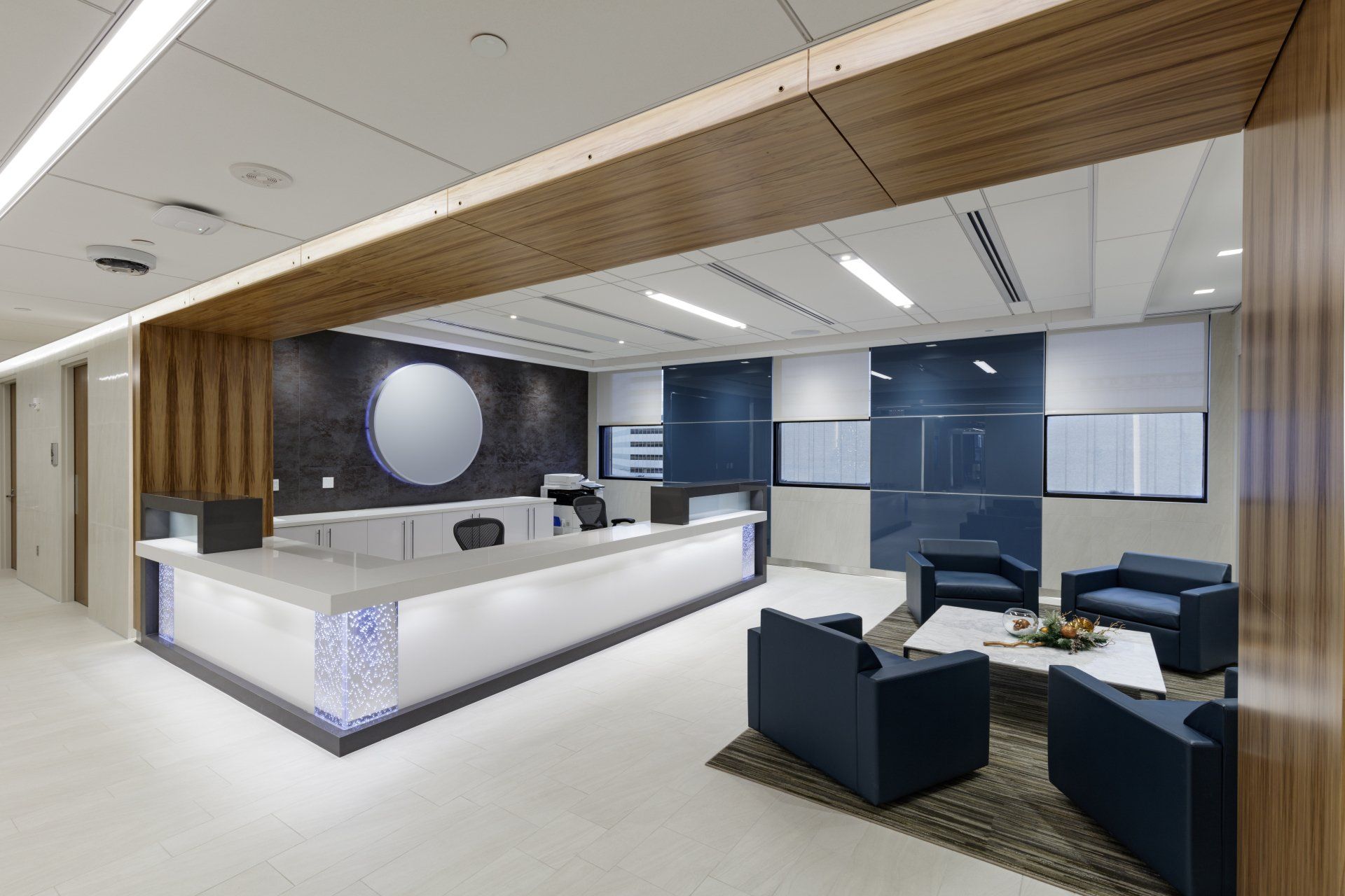 A lobby with a reception desk , chairs , and a coffee table.