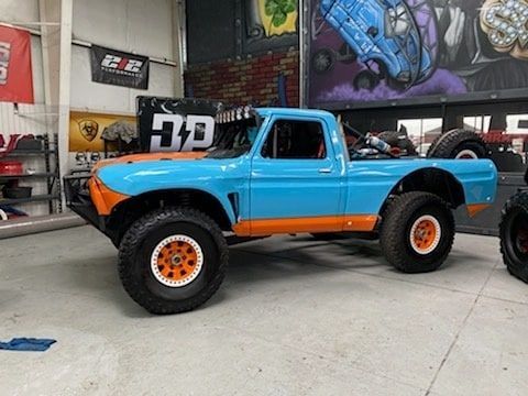 A silver car is parked in front of a building.