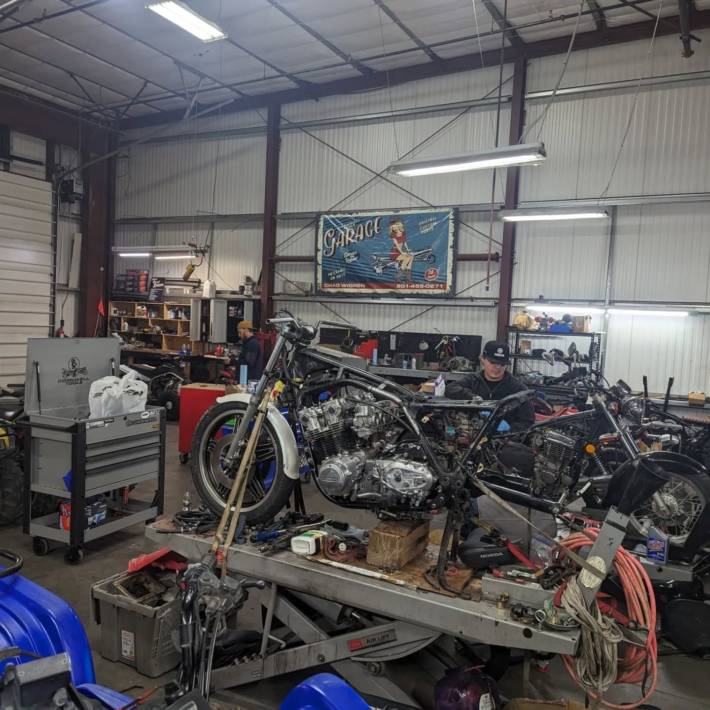 A man is working on a motorcycle in a garage.