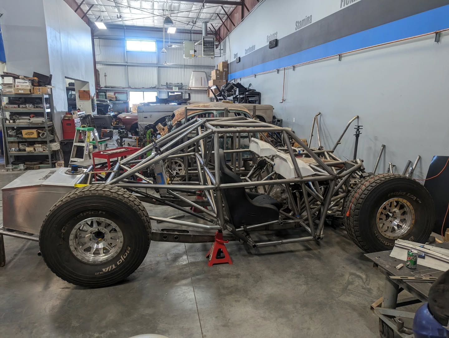 A dune buggy is being built in a garage.