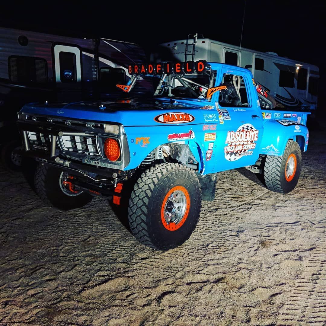 A silver car is parked in front of a building.