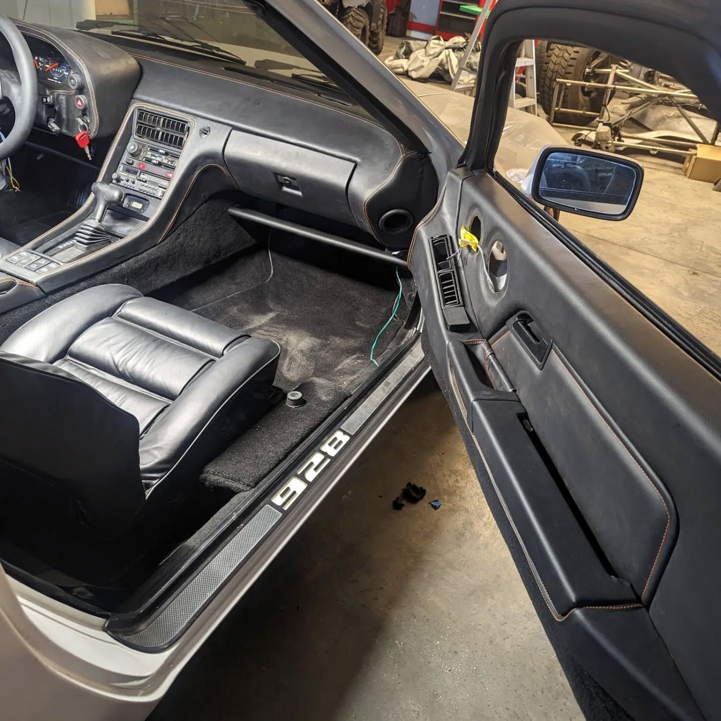 The interior of a porsche 928 with the door open
