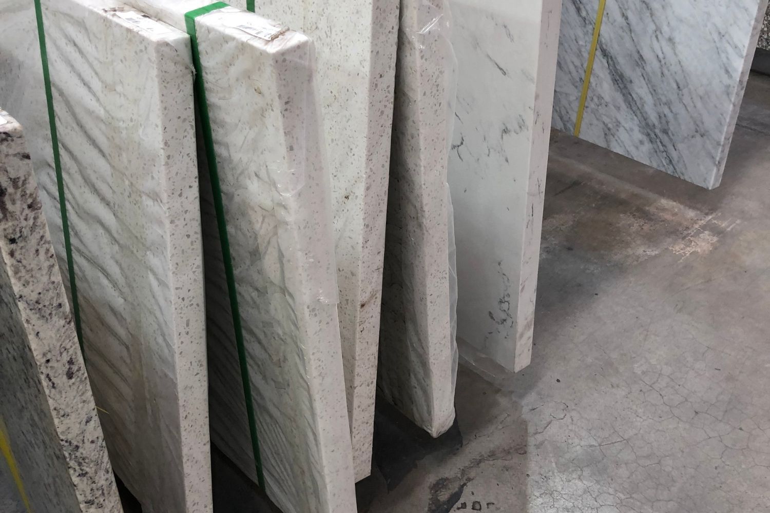 A bunch of marble slabs stacked on top of each other on a concrete floor.