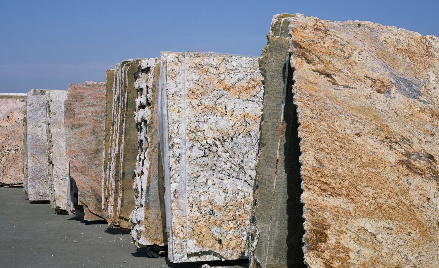 A row of granite slabs are lined up in a warehouse