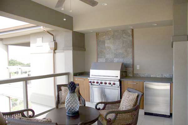 A balcony with a table and chairs and a grill.