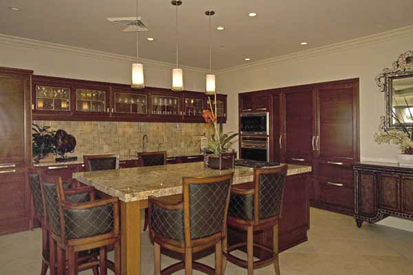 A kitchen with a large island , a table and chairs.