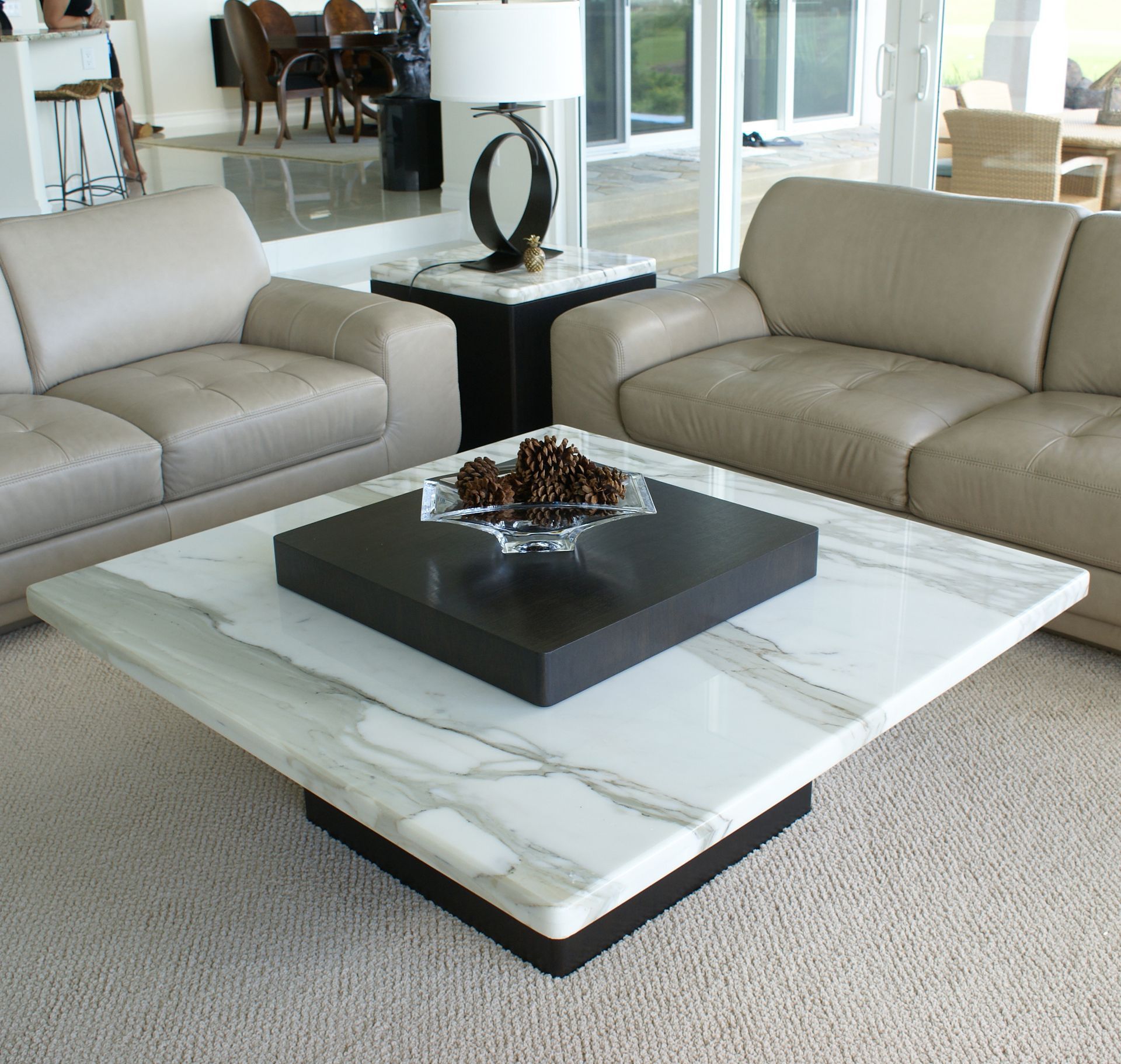 A living room with two couches and a coffee table with a bowl of pine cones on it