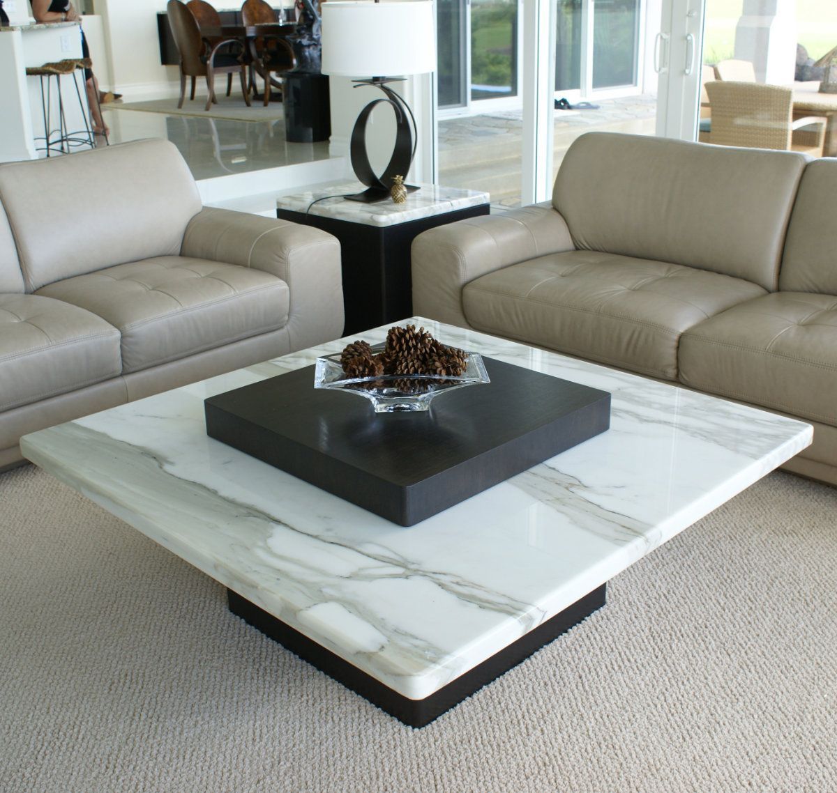 A living room with two couches and a coffee table with a bowl of pine cones on it