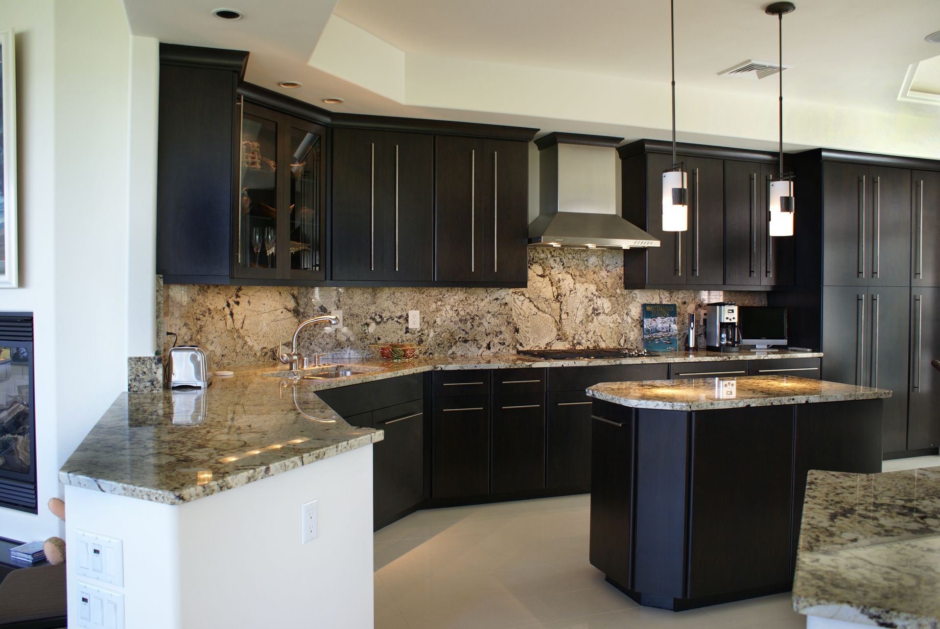 A kitchen with black cabinets and granite counter tops