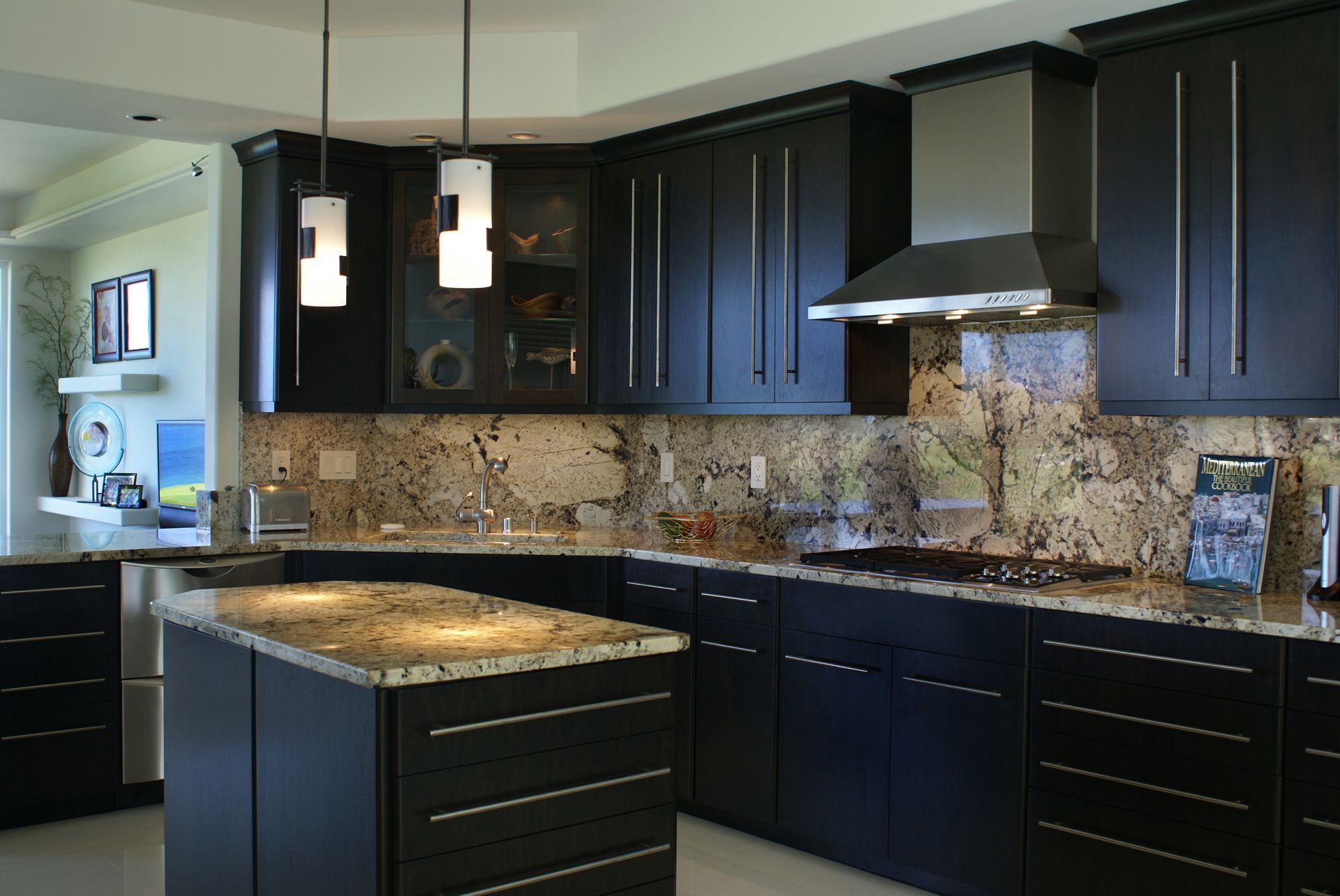 A kitchen with black cabinets and granite counter tops
