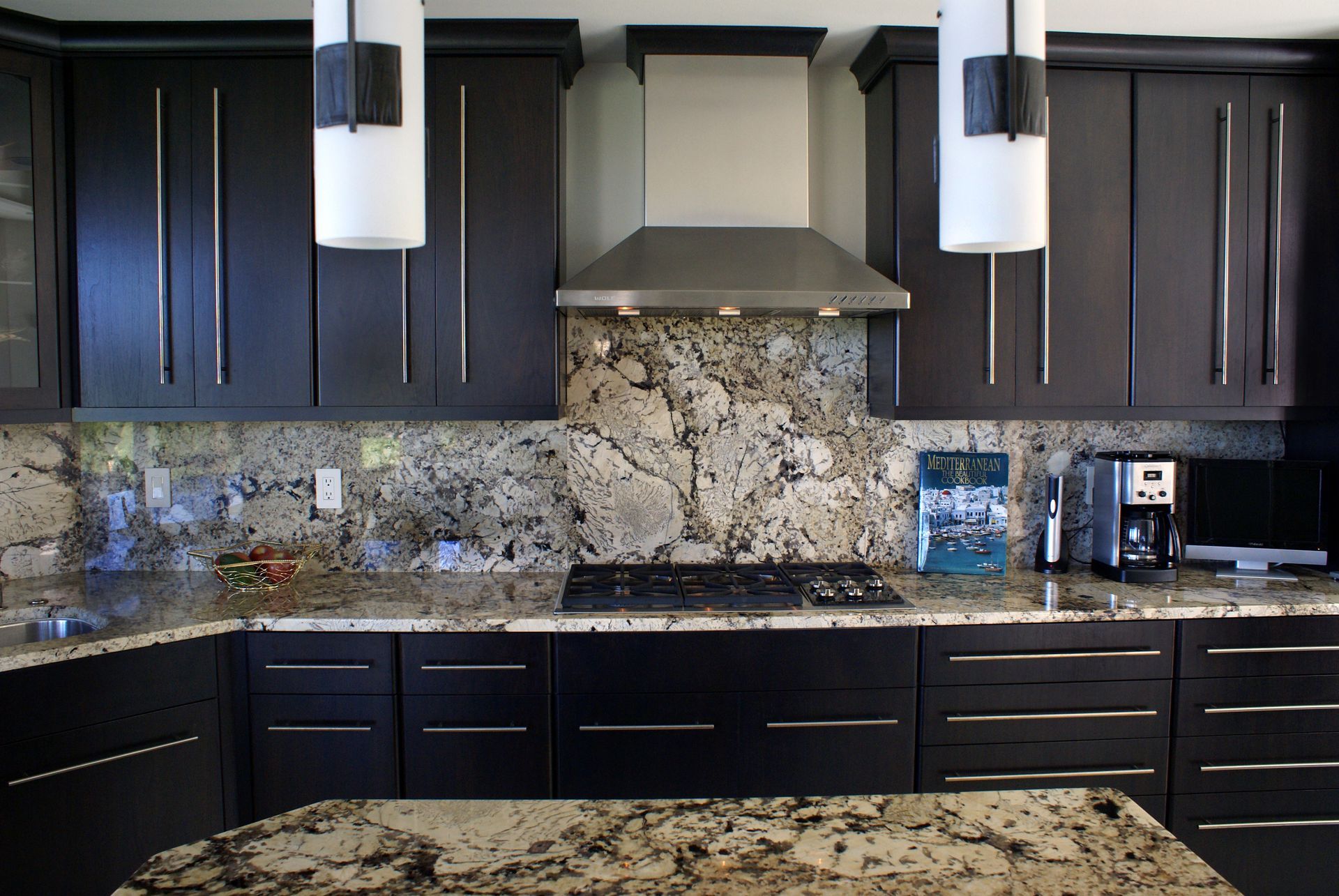 A kitchen with black cabinets and granite counter tops