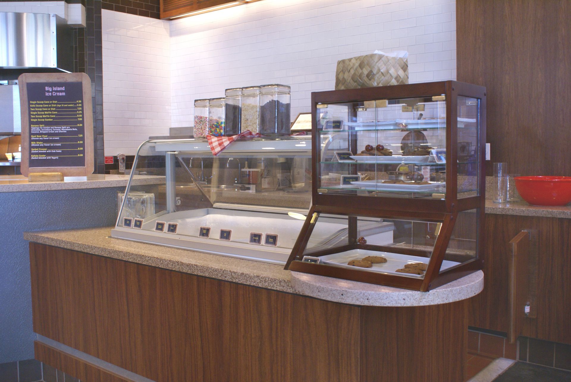 A bakery counter with a glass display case filled with food