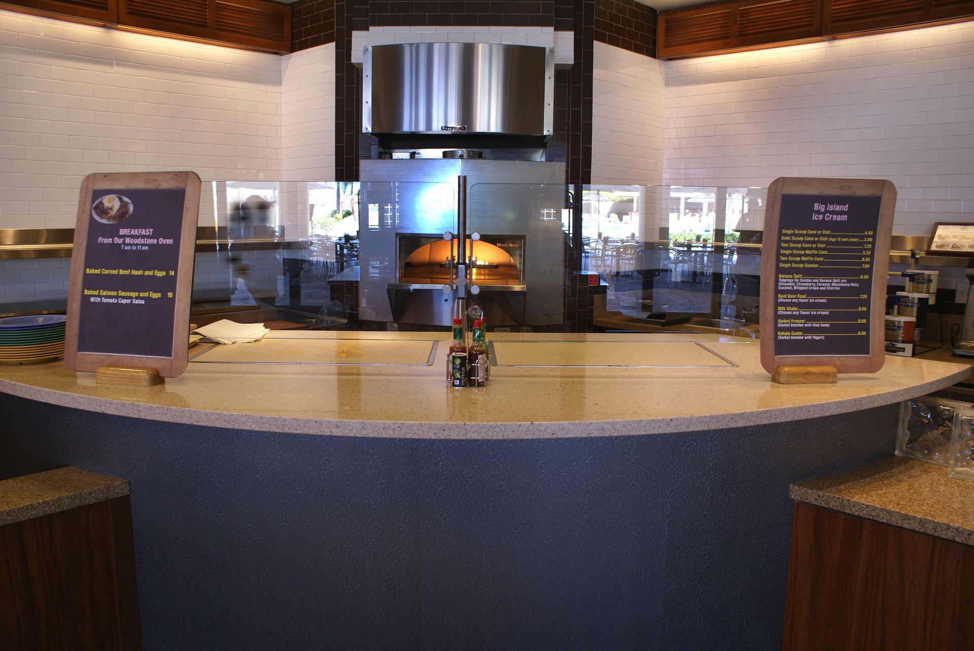 A counter in a restaurant with a pizza oven in the background