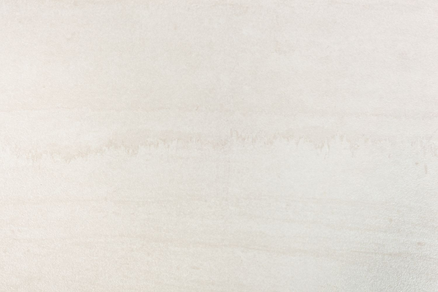 A close up of a white tile with a grainy texture.