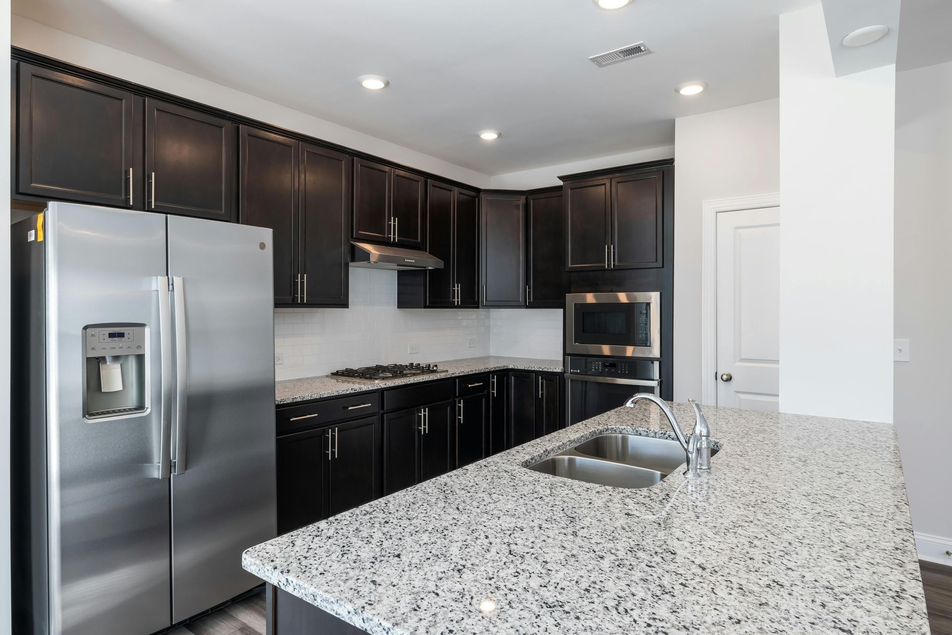 A kitchen with stainless steel appliances and granite counter tops.