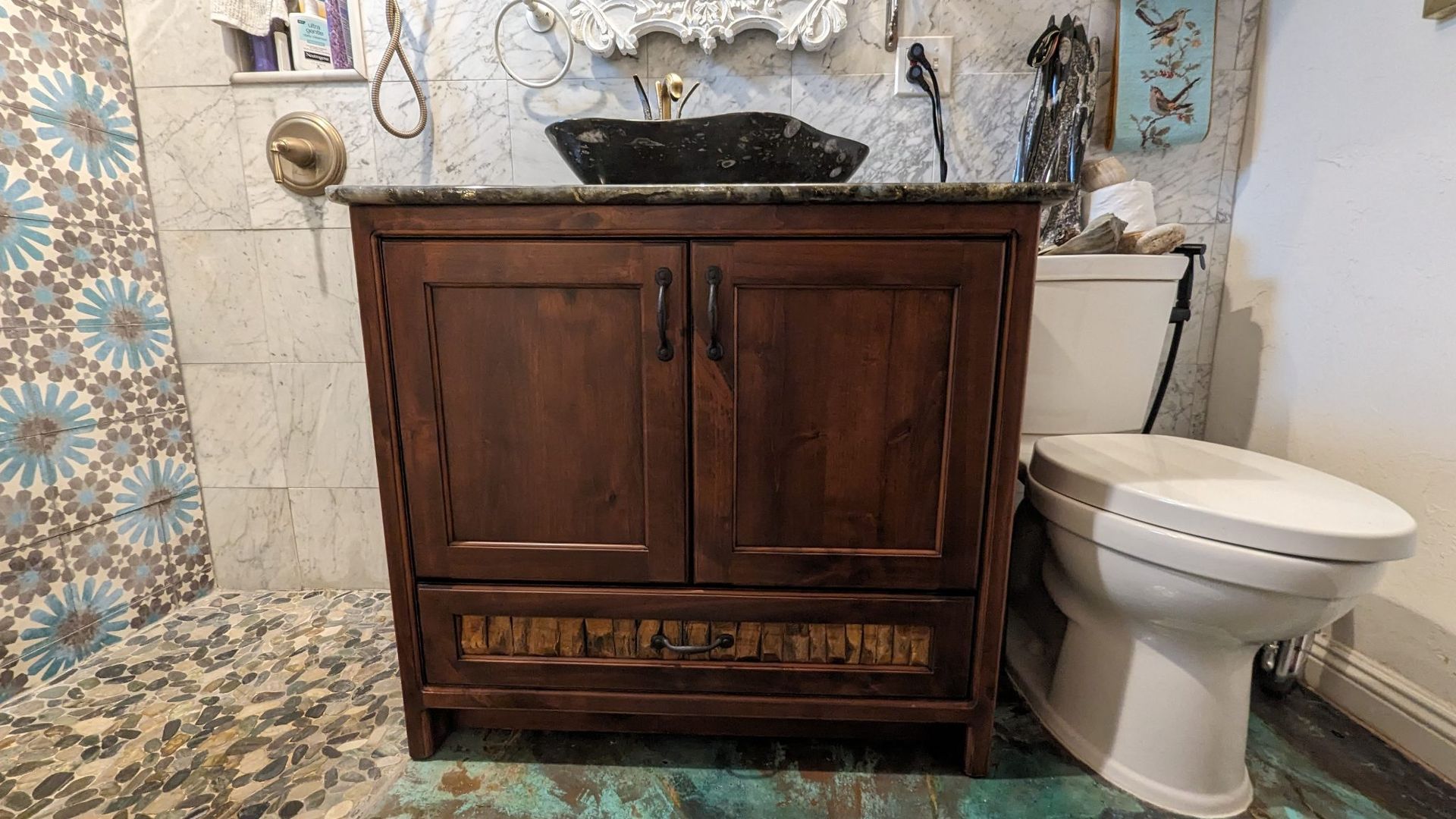 A bathroom with a wooden vanity , toilet and sink.
