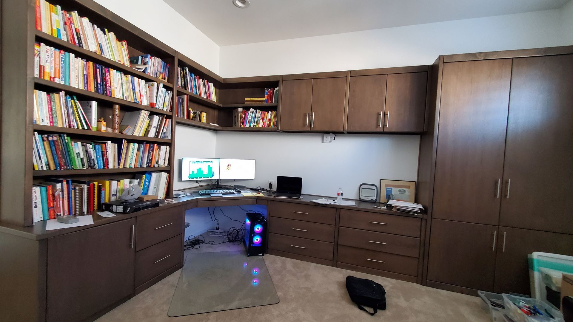 A room with a lot of bookshelves and a desk with a computer on it.