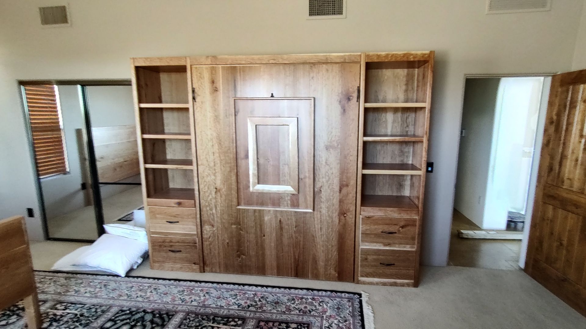 A bedroom with a large wooden wall mounted bed