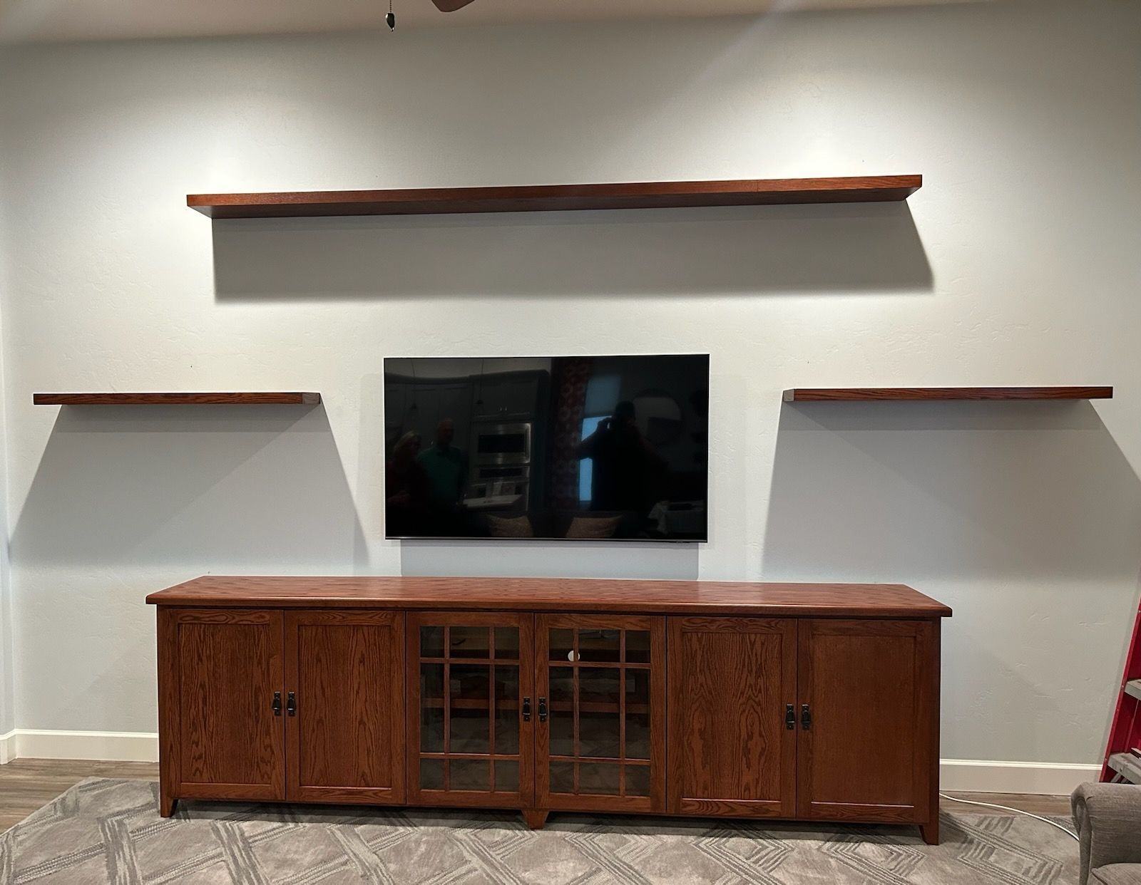 A living room with a wooden entertainment center and a flat screen tv.