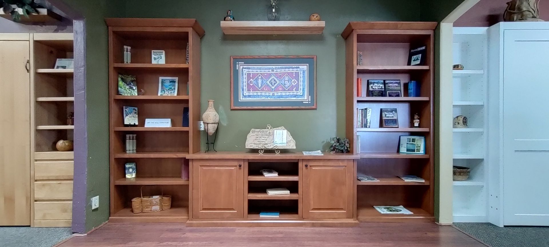 A room with lots of shelves and a picture on the wall