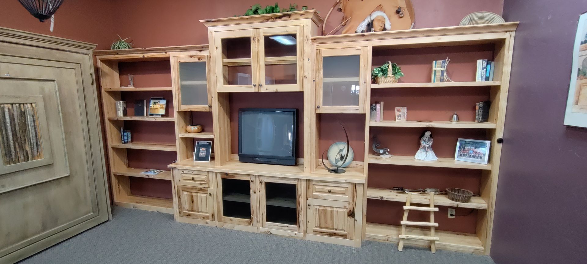 A large wooden entertainment center with a flat screen tv