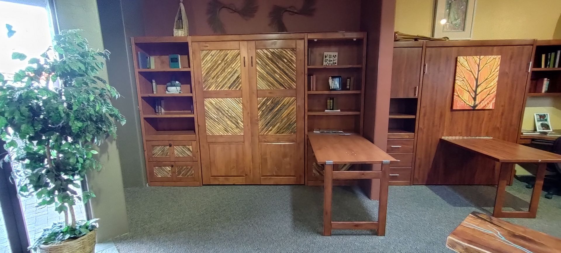 A room with lots of wooden furniture and a plant