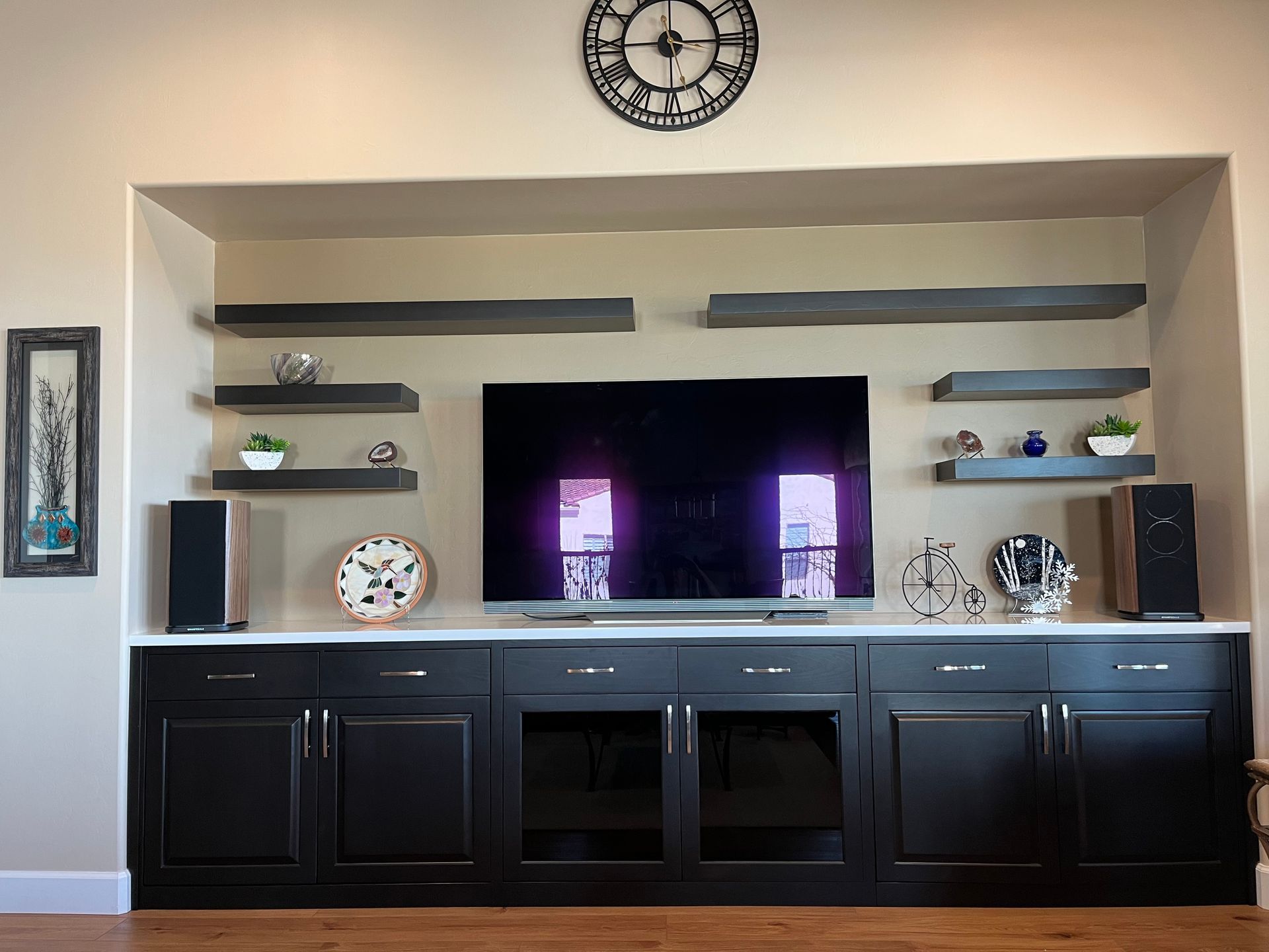 A living room with a flat screen tv and a clock on the wall