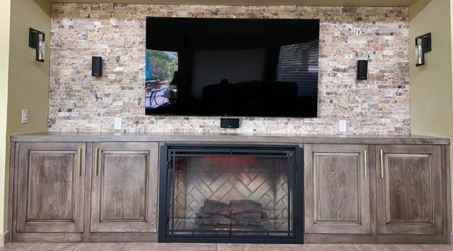 A living room with a fireplace and a flat screen tv.
