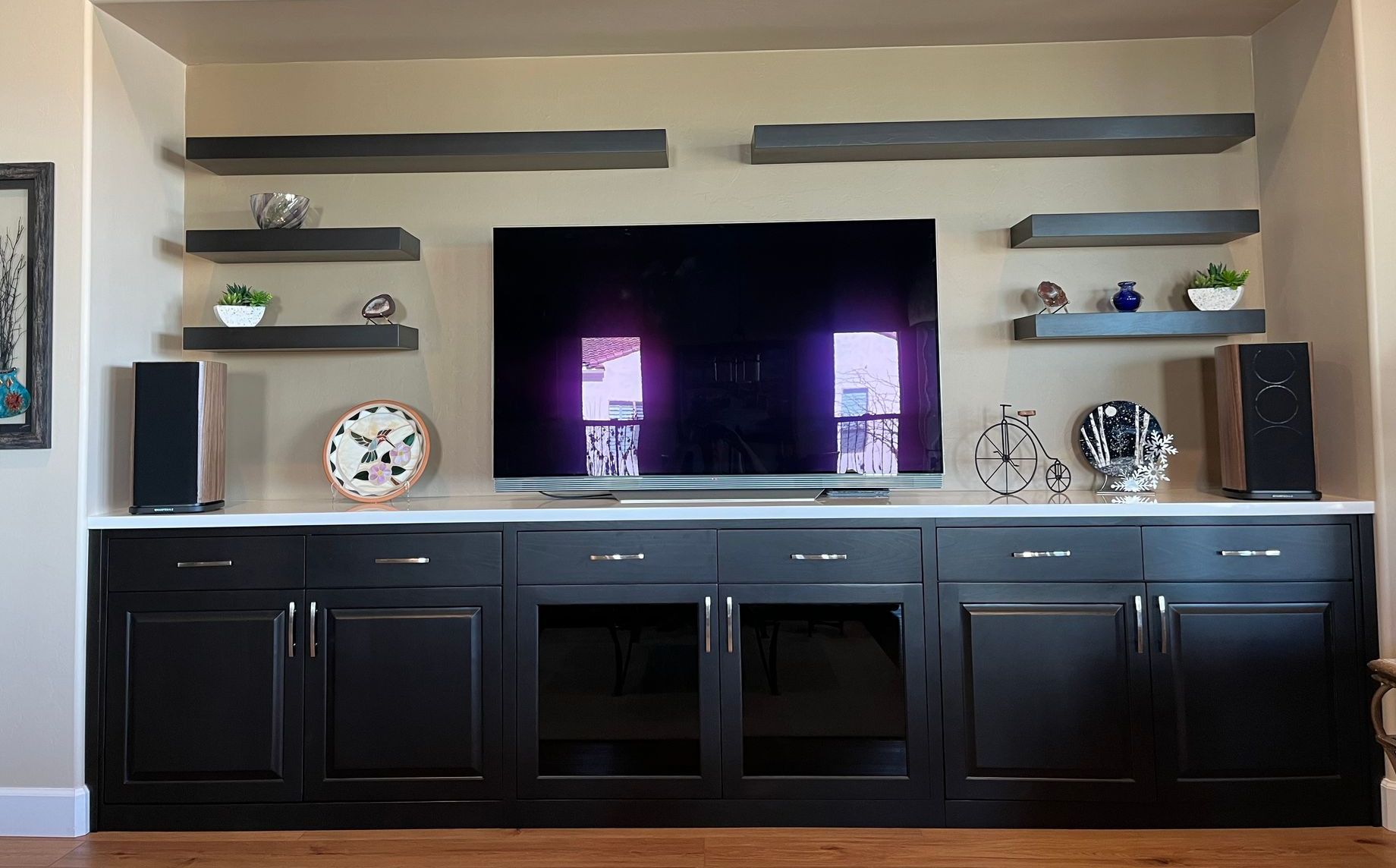 A living room with a flat screen tv and shelves