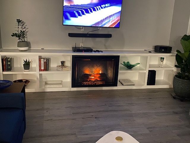 A living room with a fireplace and a flat screen tv