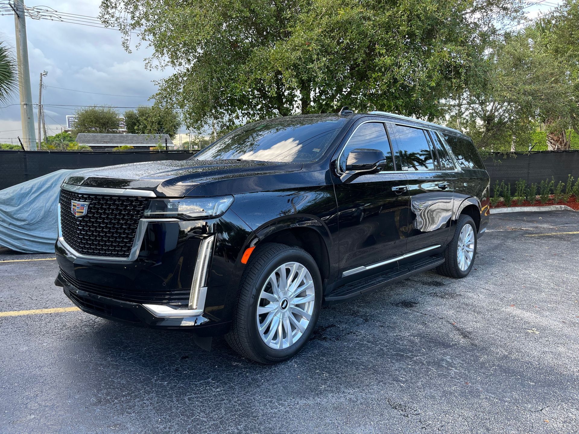 Black Cadillac Escalade parked outdoors on an overcast day.