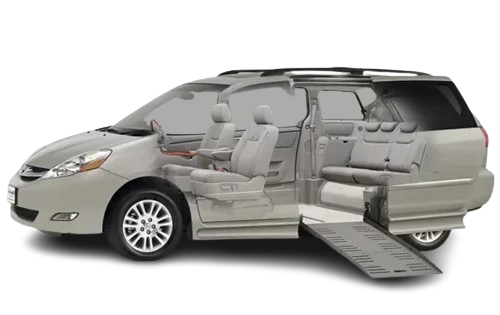 Accessible silver minivan with a deployed ramp. Interior seats visible.