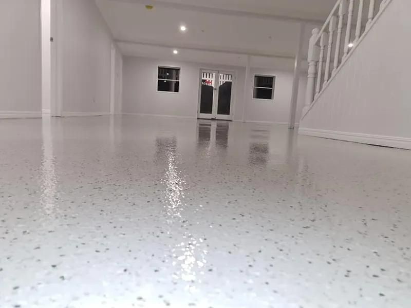 A Large Empty Room With a White Floor and Stairs — Alan Aldridge Floor Sanding in Urraween, QLD