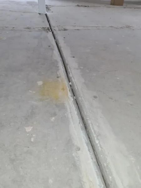 A Concrete Floor With a Drain in the Middle of It — Alan Aldridge Floor Sanding in Urraween, QLD