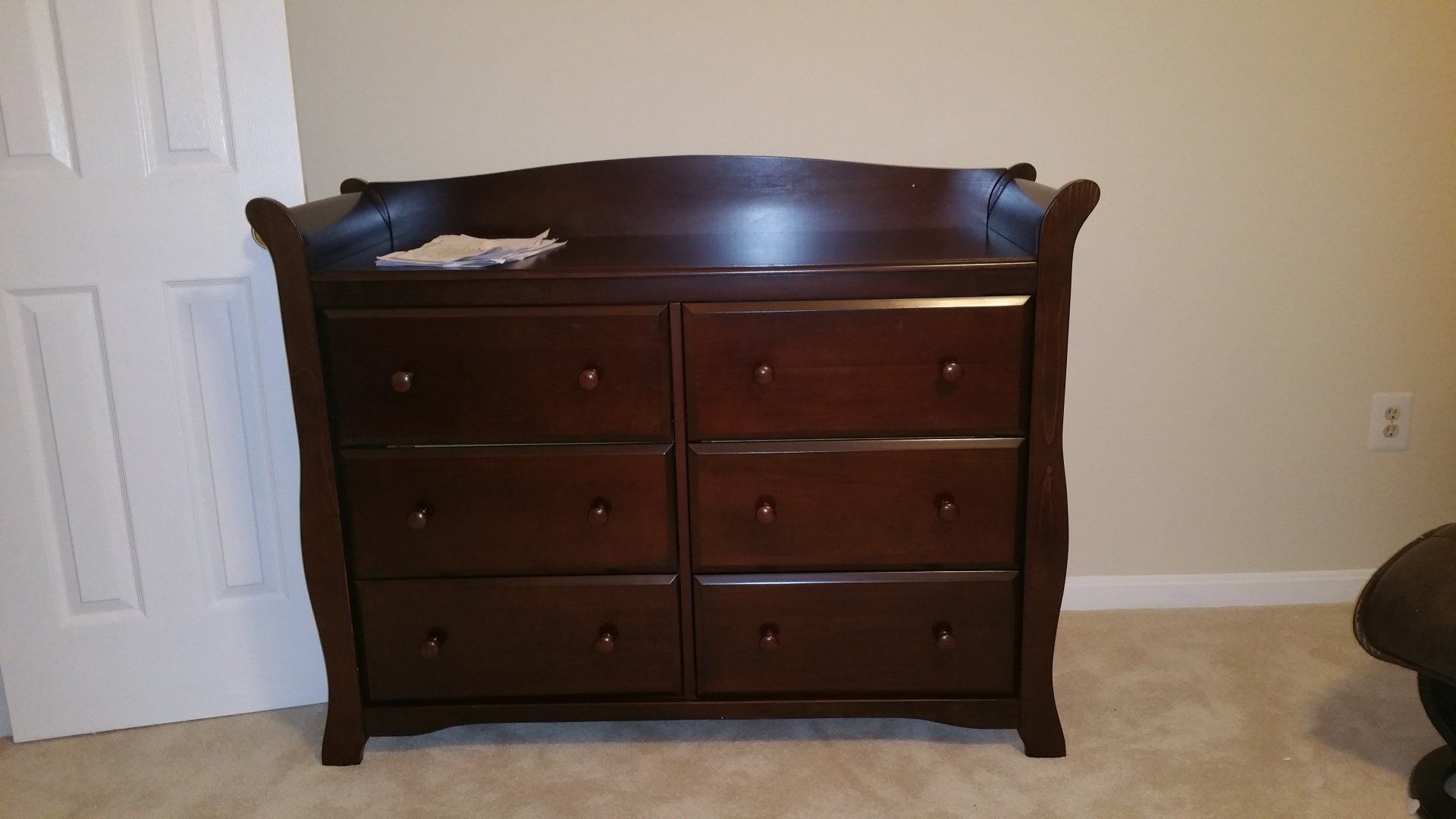 A dresser with a changing table on top of it