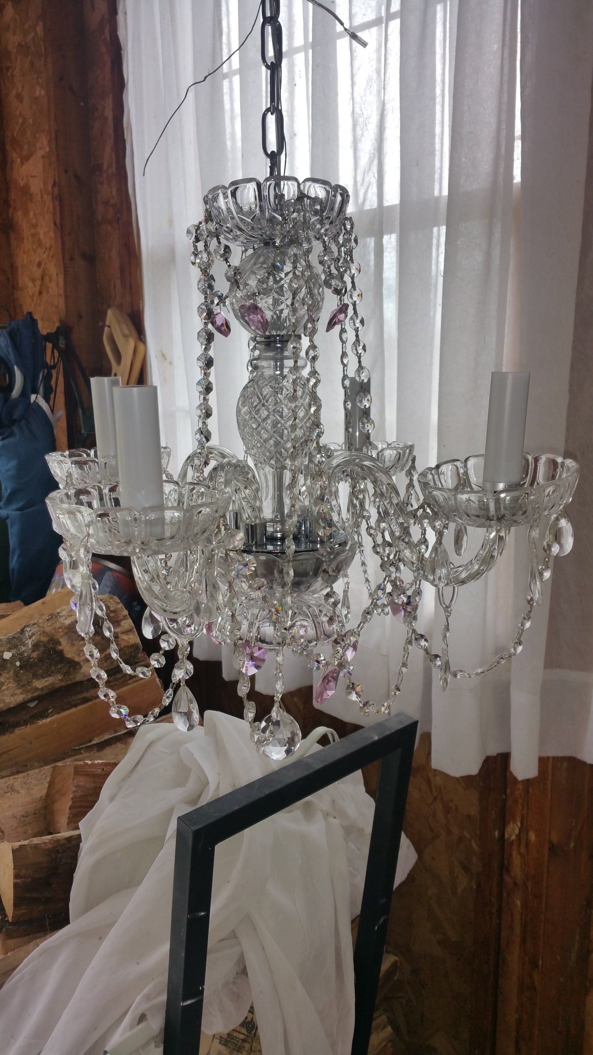 A crystal chandelier is hanging from the ceiling in a living room.