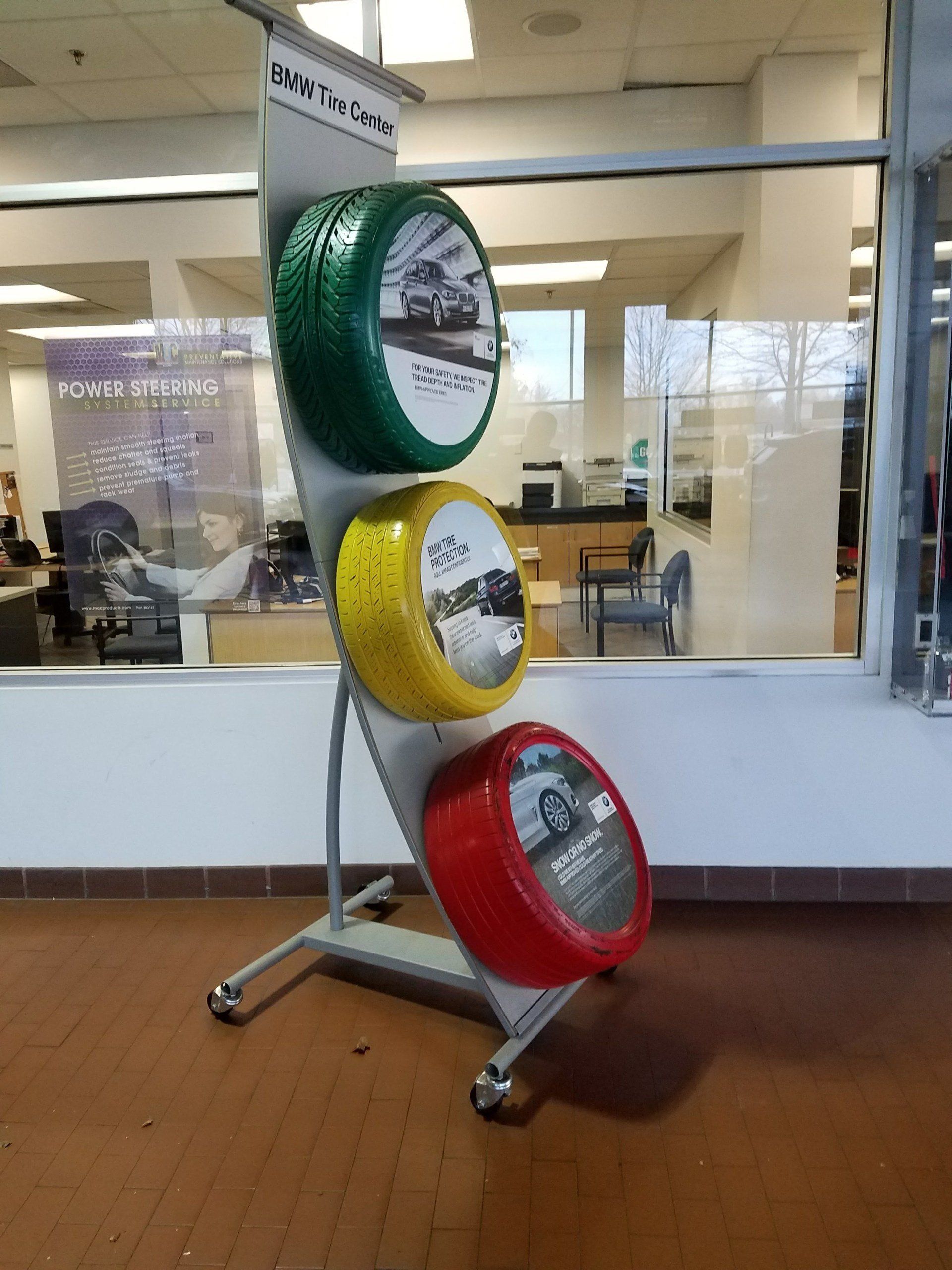 Three tires are displayed on a stand in a showroom.