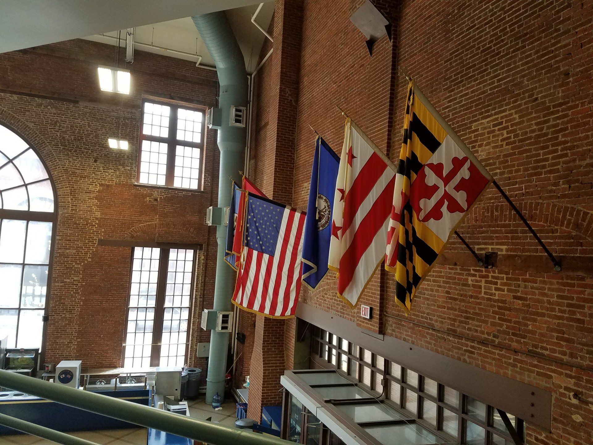 A row of flags are hanging on a brick wall