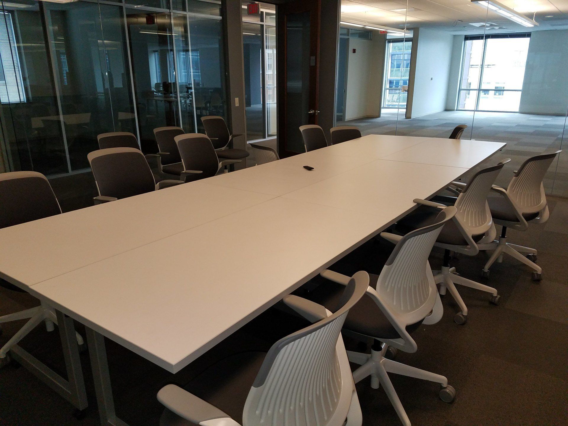 A conference room with a long white table and chairs